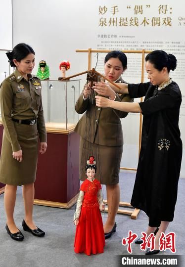 图为外国留学生向泉州市提线木偶戏传承保护中心演员庄丽娥(右)学习提线木偶戏。泉州提线木偶戏是福建省泉州市传统戏剧，2006年被列入国家级非物质文化遗产名录，至今保存着700余出传统剧目和由300余支曲牌唱腔构成的独有剧种音乐“傀儡调”。中新社记者 张斌 摄