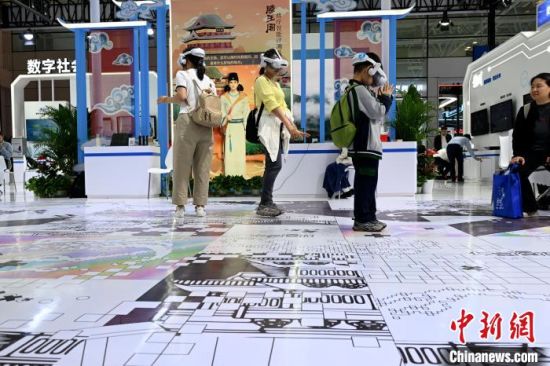 4月28日，第八届数字中国建设峰会现场体验区在福建福州海峡国际会展中心开放。本次现场体验区面积5.6万平方米，围绕“数智引领高质量发展”主题，首次设立低空经济专区，人工智能和数据元素突出。图为观众佩戴VR设备与AI数字人“王勃”共游滕王阁。　中新社记者 吕明 摄