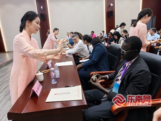 外交官员体验用南音四宝和酒盏发出的清脆声音。东南网记者 谢玉妹 摄